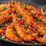 Crispy garlic fried shrimp with golden shell-on shrimp, toasted garlic butter, green onions, and a tangy suka dipping sauce.